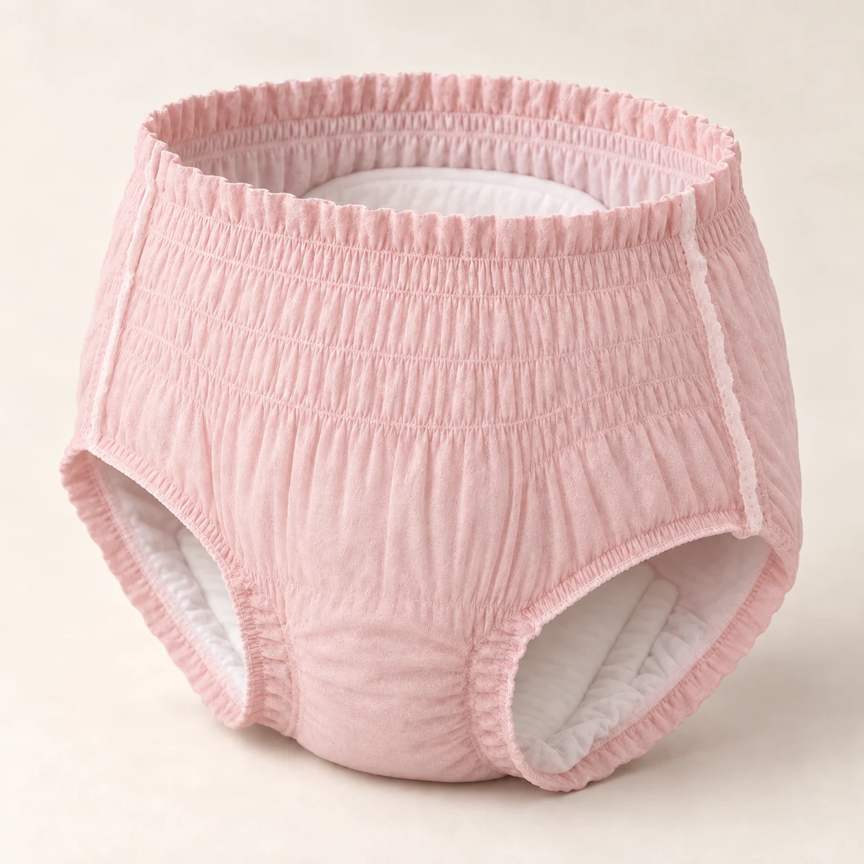 Illustrative disposable period pant with a blush nonwoven outer shell and white inner insert.