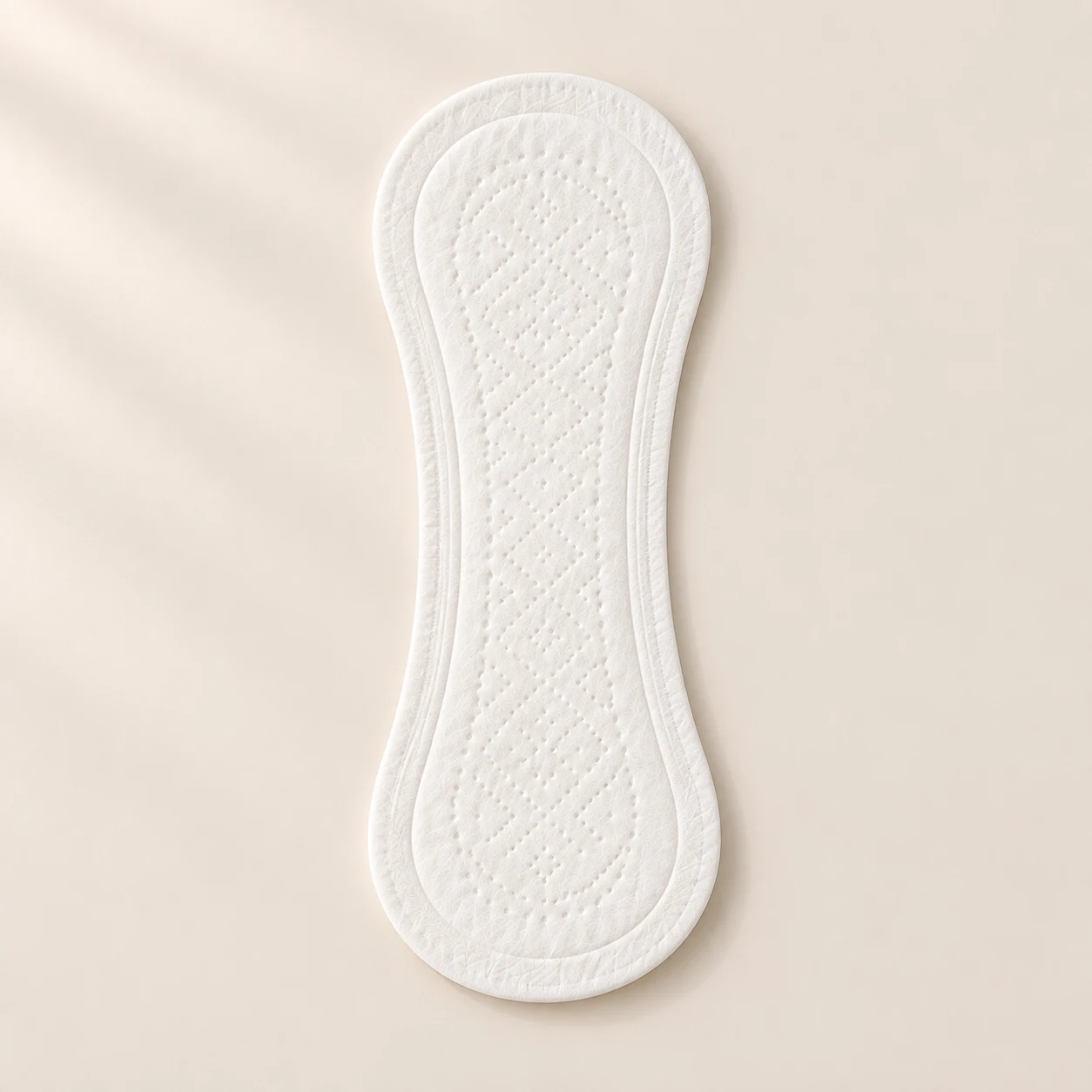 Illustrative thin white wingless panty liner with rounded ends, a narrow waist and subtle dotted embossing.